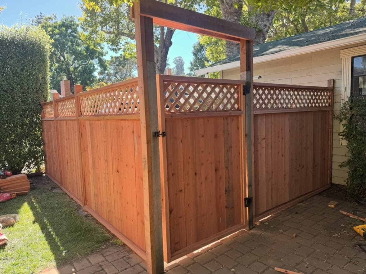 Wood gate and fence project with lattice detail and outdoor walkway.